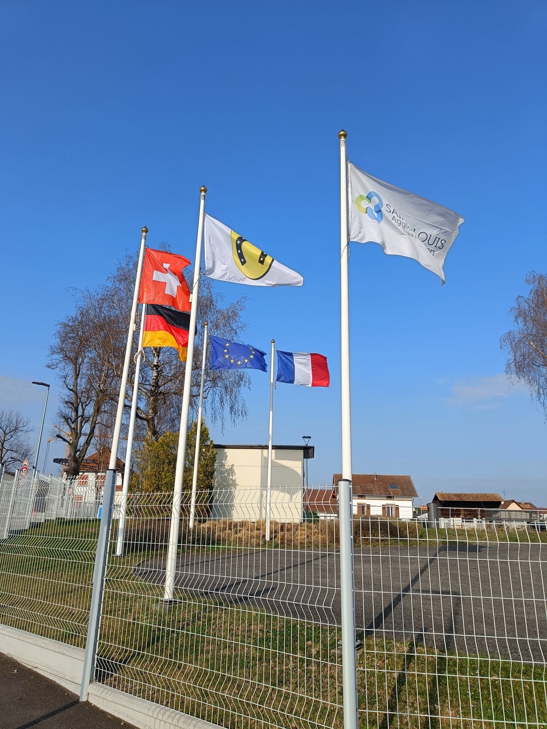 Drapeaux de la Suisse, de l’Allemagne, de l’Union européenne, de la France et de Saint-Louis Agglomération — territoire transfrontalier