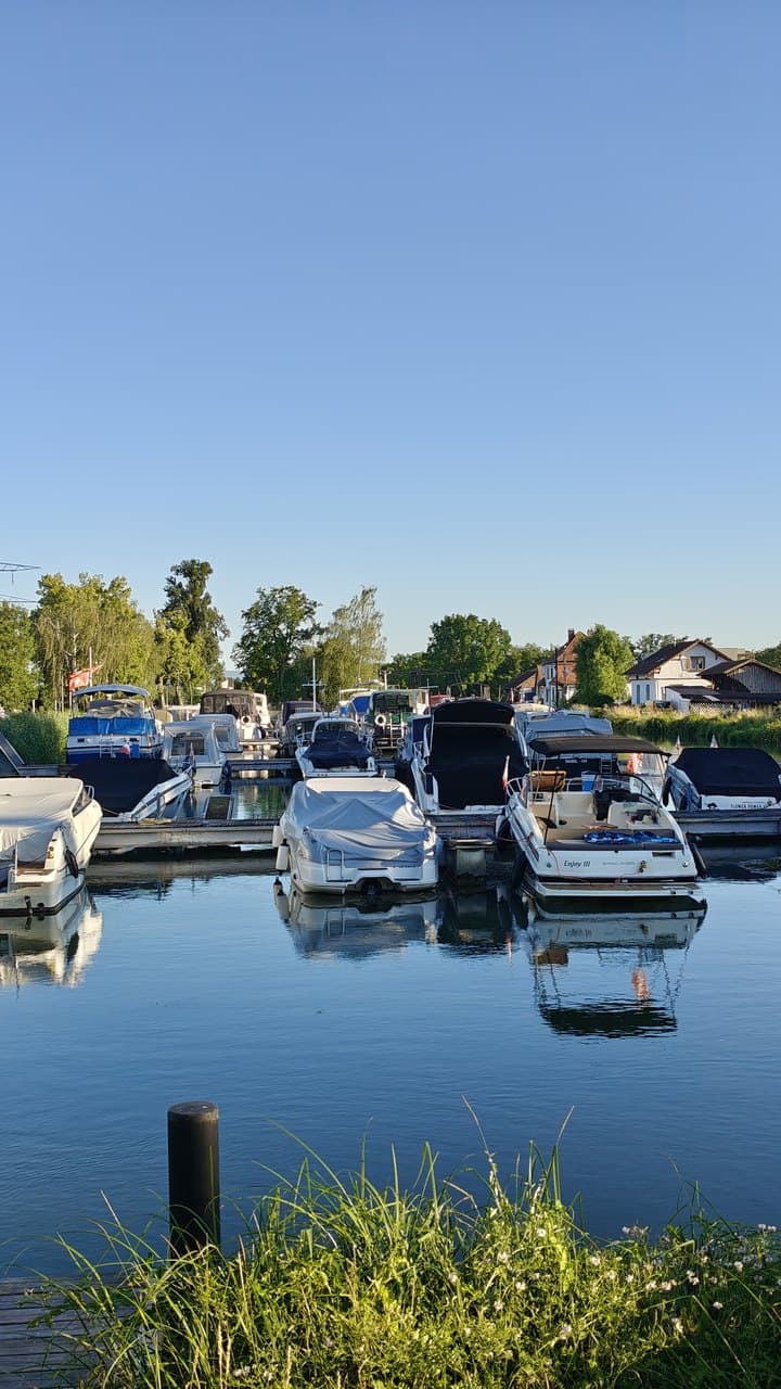 Le port de plaisance de Kembs au coucher du soleil, bateaux amarrés et reflets sur l’eau