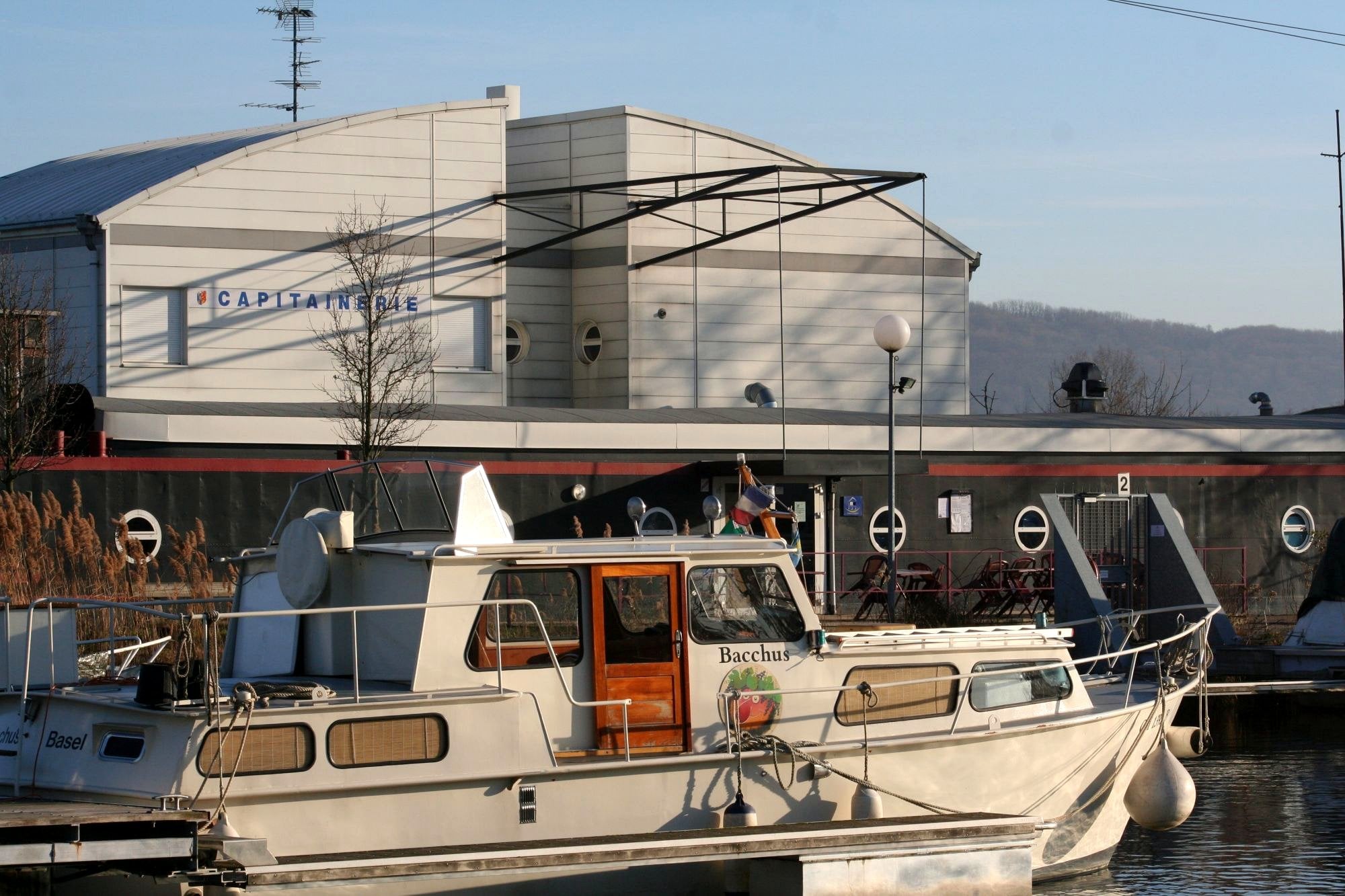 La capitainerie du port de Kembs et un bateau amarré le long du quai